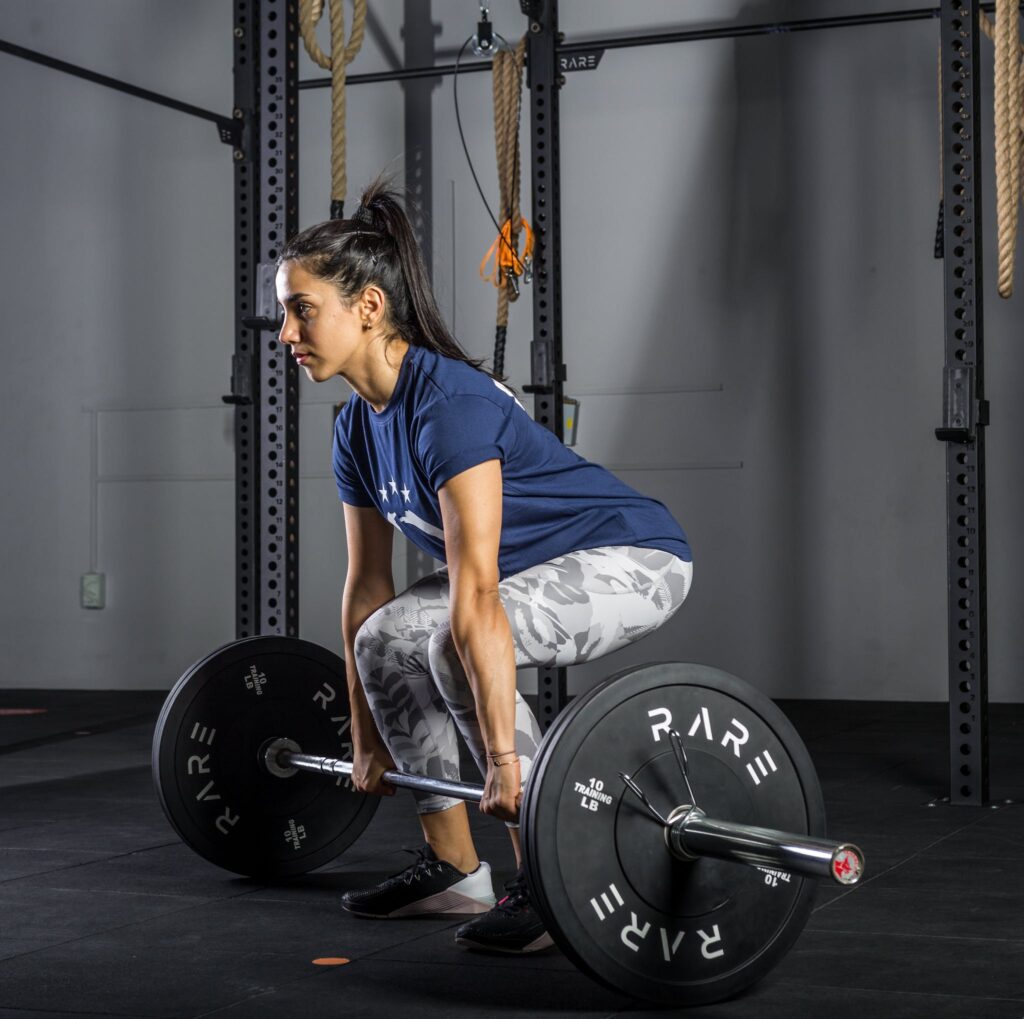 Young Woman in Sports Wear Lifting Barbell